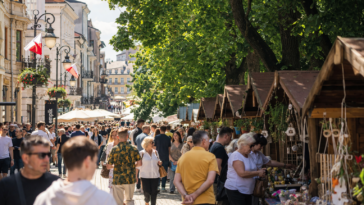 Tłumy spacerujące po jarmarku regionalnym podczas majówki w Rzeszowie, stoiska z rękodziełem i lokalnymi produktami w centrum miasta.